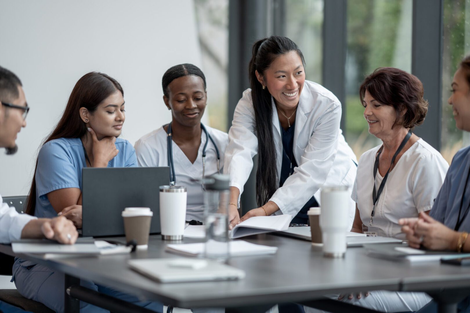 Diverse healthcare professionals collaborating around a table in a meeting.
