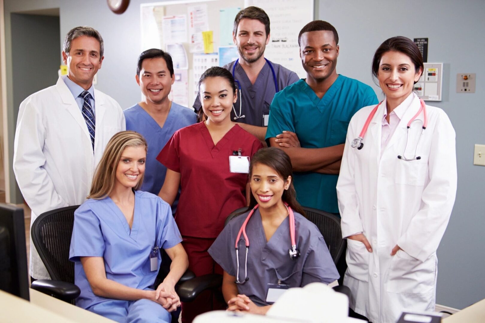 A diverse group of healthcare professionals posing together in a medical setting.